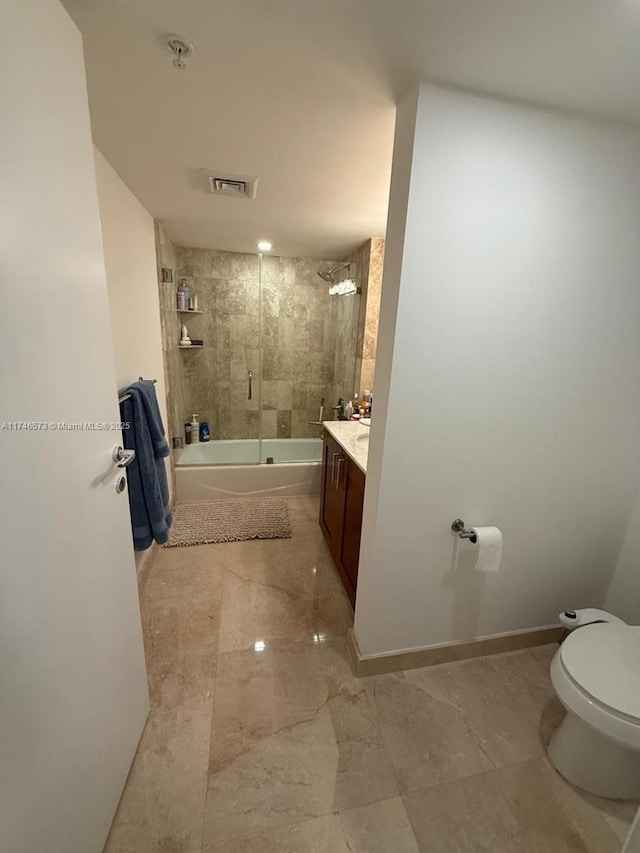 full bathroom with vanity, tiled shower / bath combo, and toilet