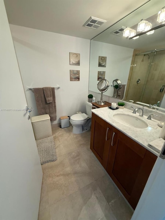 bathroom featuring vanity, a shower with door, and toilet