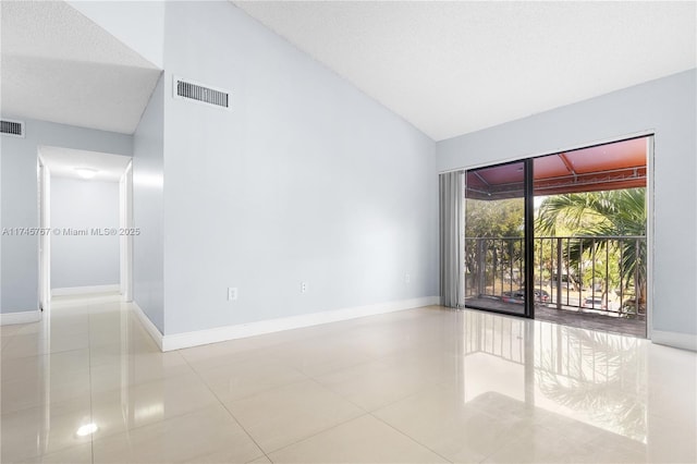 tiled empty room featuring lofted ceiling, baseboards, and visible vents