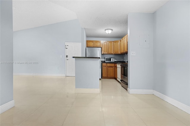 kitchen with stainless steel appliances, dark countertops, brown cabinetry, a textured ceiling, and baseboards