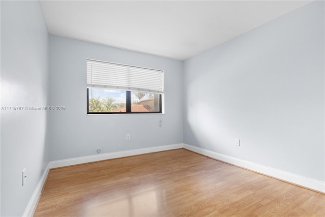 spare room featuring light wood-style floors and baseboards