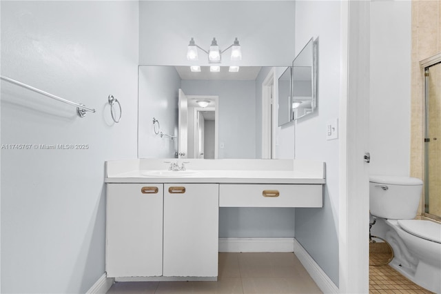 bathroom with toilet, vanity, baseboards, and tile patterned floors