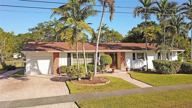 single story home featuring a garage and a front yard