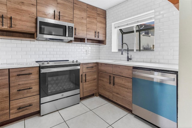 kitchen with brown cabinets, appliances with stainless steel finishes, open shelves, and light countertops