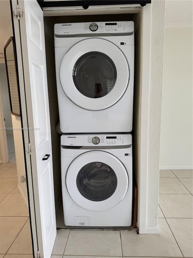 washroom with stacked washer / dryer, laundry area, and light tile patterned floors