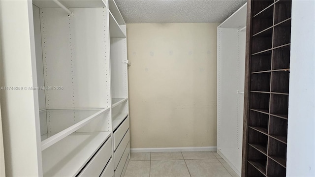 walk in closet with light tile patterned floors