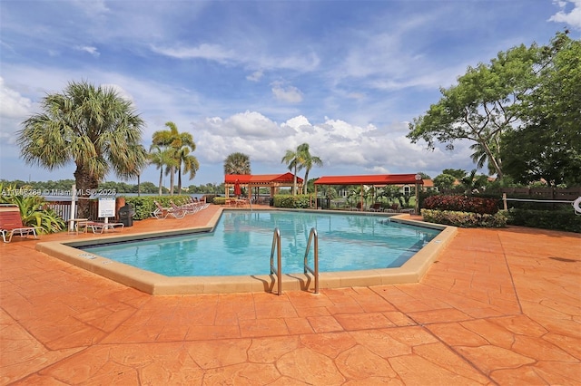 pool with a patio area and fence