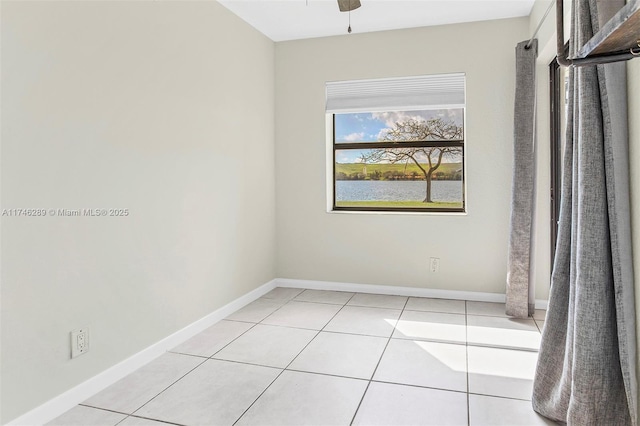 empty room with light tile patterned floors, ceiling fan, and baseboards