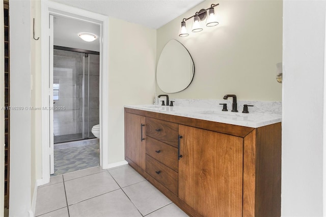 full bathroom featuring double vanity, tile patterned flooring, toilet, and a sink