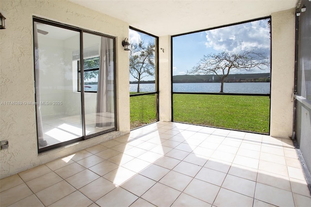 unfurnished sunroom featuring a water view