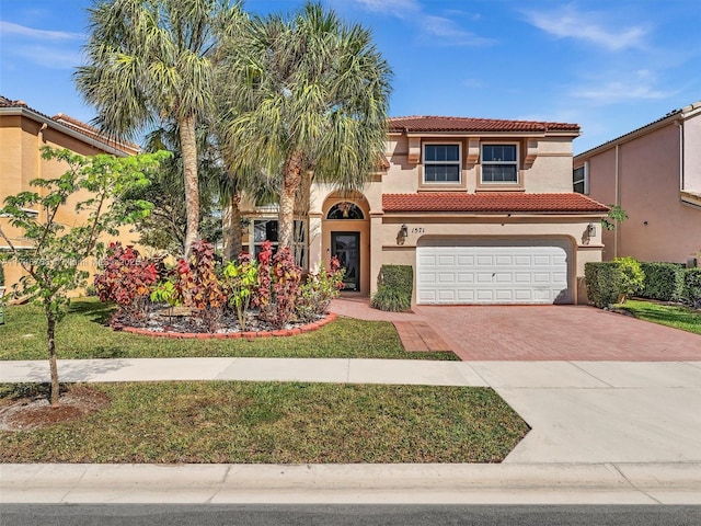 mediterranean / spanish house with a garage and a front yard