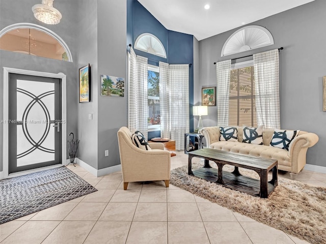 entrance foyer with a towering ceiling, baseboards, and light tile patterned flooring