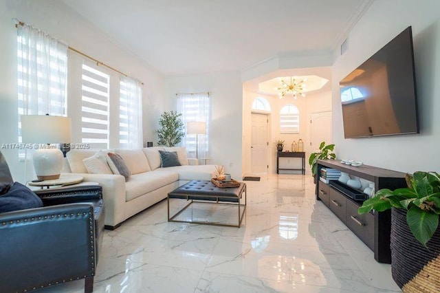 living room with ornamental molding and a notable chandelier