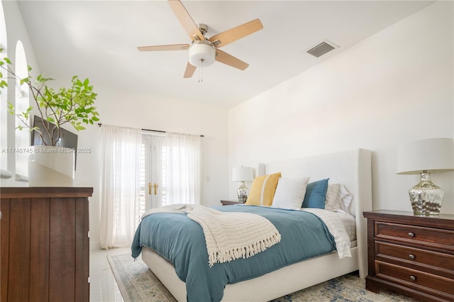 bedroom with access to exterior, french doors, and ceiling fan