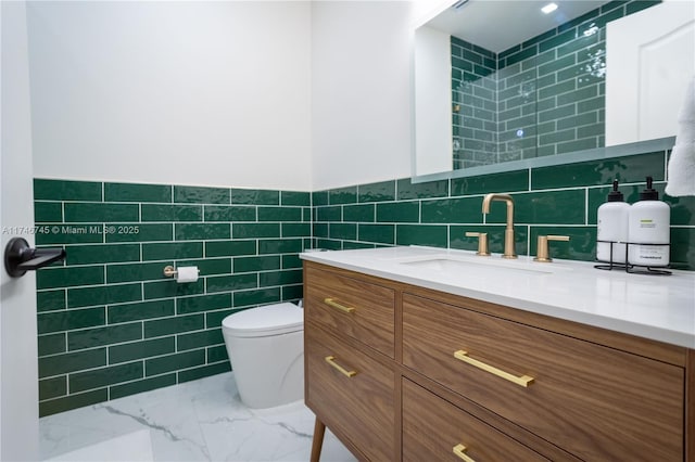 bathroom featuring vanity, tile walls, and toilet