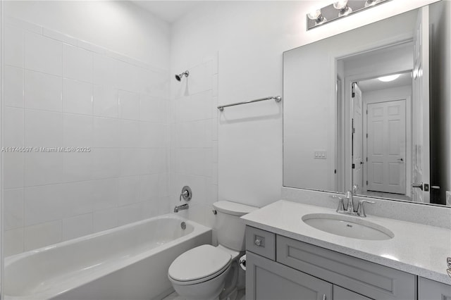 full bathroom with tiled shower / bath, vanity, and toilet
