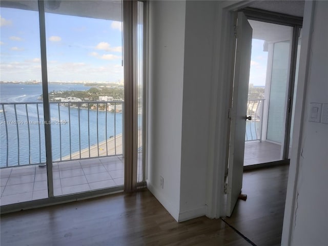 doorway to outside featuring dark hardwood / wood-style floors and a water view