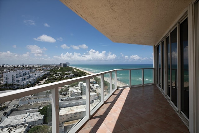 balcony featuring a view of the beach and a water view