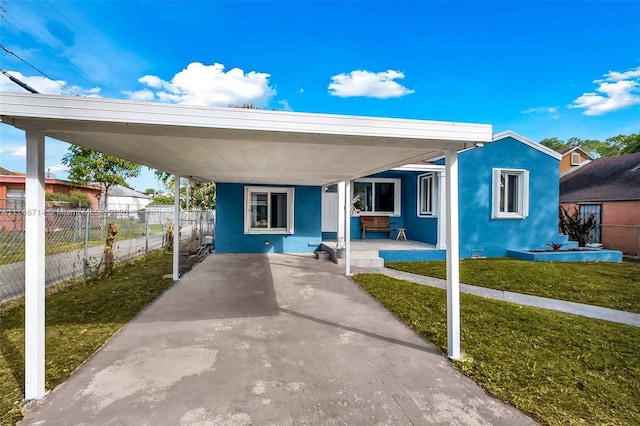 4711 NW 11th Ave, Miami, FL 33127 - view of front of house with an attached carport, a front yard, fence, and stucco siding