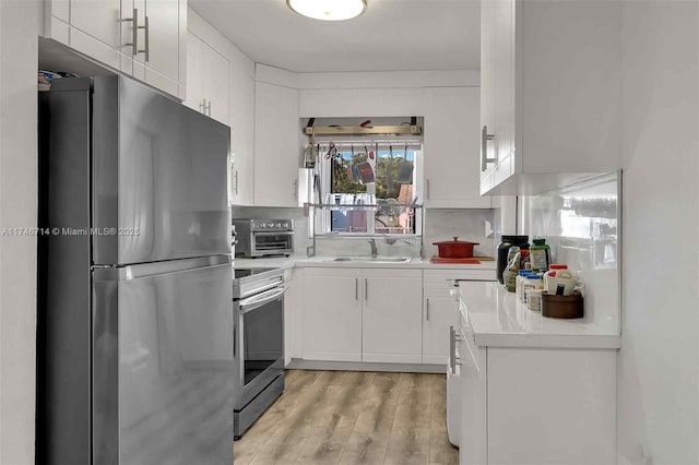 4711 NW 11th Ave, Miami, FL 33127 - kitchen featuring white cabinetry, light countertops, stainless steel appliances, a toaster, and a sink