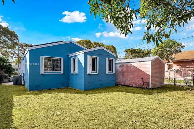 4711 NW 11th Ave, Miami, FL 33127 - rear view of property featuring central air condition unit, crawl space, fence, and a lawn