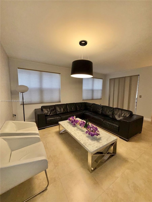 living area featuring baseboards and light tile patterned floors