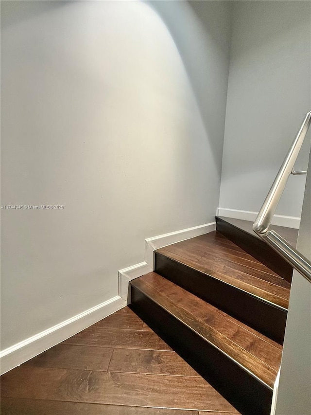stairs with wood finished floors and baseboards