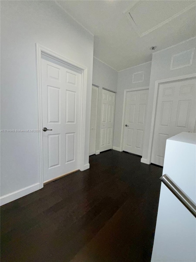 unfurnished room with dark wood-type flooring and baseboards