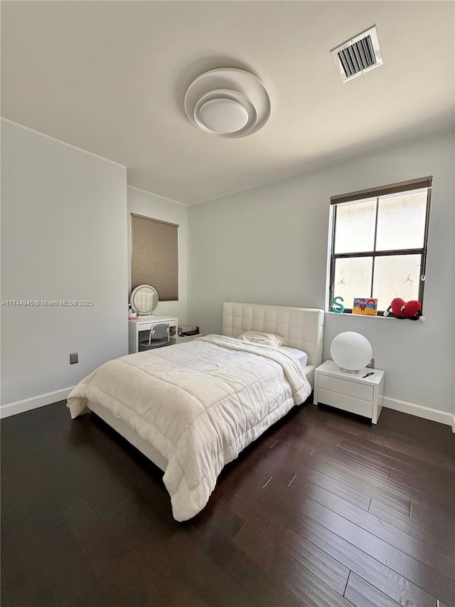 bedroom with visible vents, dark wood finished floors, and baseboards