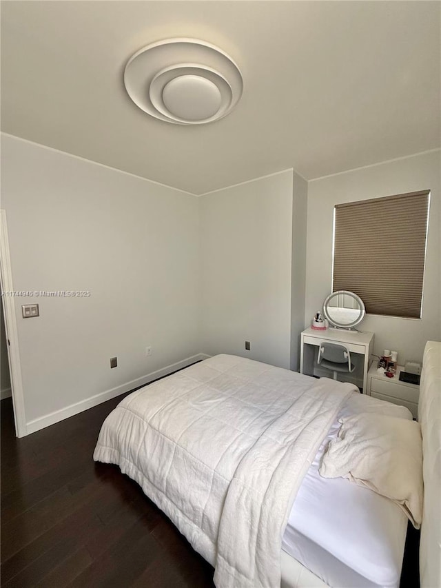 bedroom featuring dark wood-style flooring and baseboards