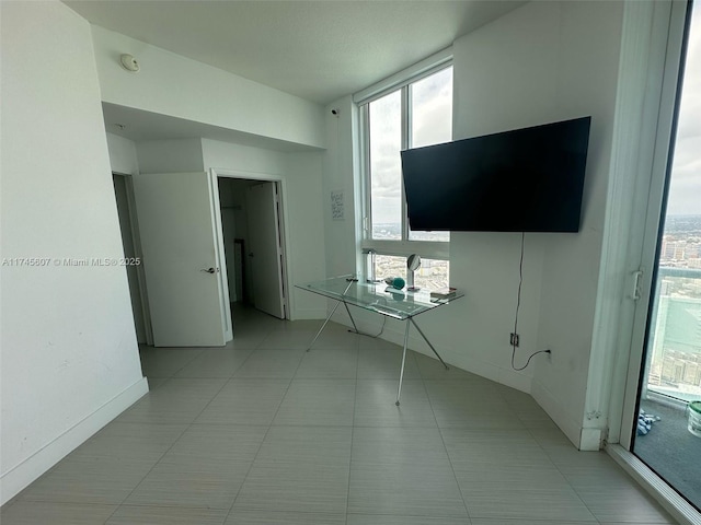 interior space with light tile patterned flooring and baseboards