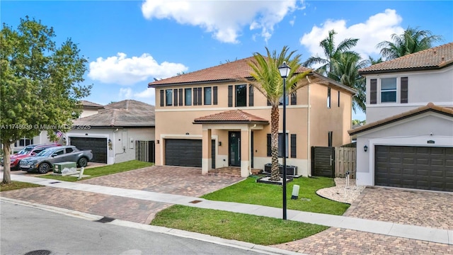 view of front of home featuring stucco siding, a tiled roof, decorative driveway, and fence