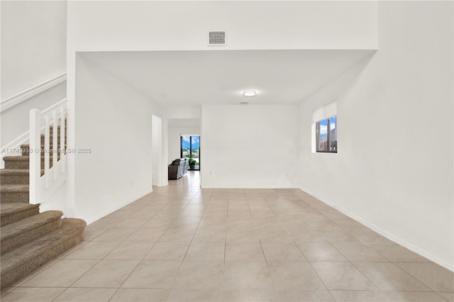 interior space featuring stairs, light tile patterned flooring, baseboards, and visible vents