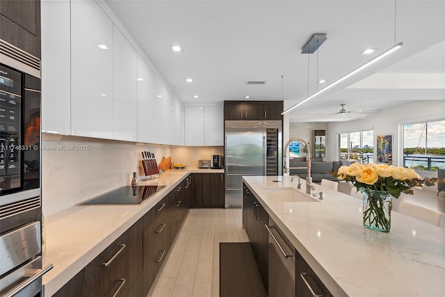 350 Desoto St, Hollywood, FL 33019 - kitchen featuring pendant lighting, white cabinets, backsplash, stainless steel appliances, and dark brown cabinets