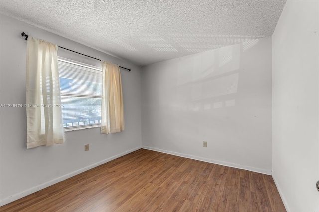 unfurnished room featuring wood-type flooring and a textured ceiling