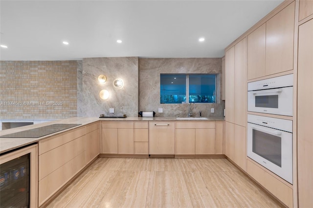 kitchen featuring a sink, wine cooler, light brown cabinets, and black electric cooktop