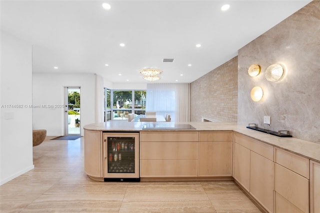 kitchen with beverage cooler, light countertops, light brown cabinetry, and a peninsula