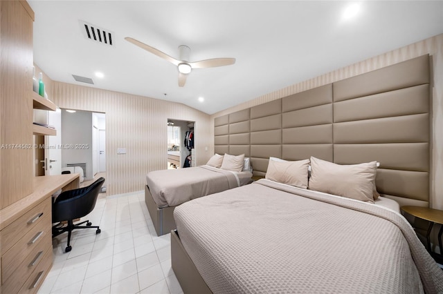 bedroom featuring wallpapered walls, built in study area, visible vents, and a walk in closet