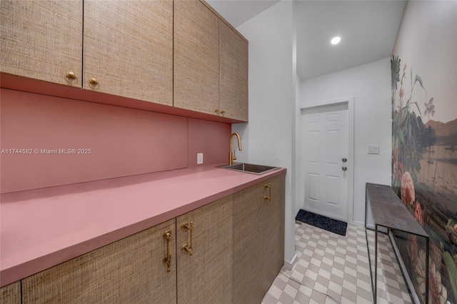 kitchen with recessed lighting, a sink, baseboards, light countertops, and light floors