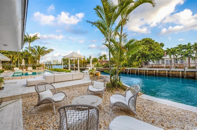 outdoor pool with a patio area, a water view, and an outdoor hangout area