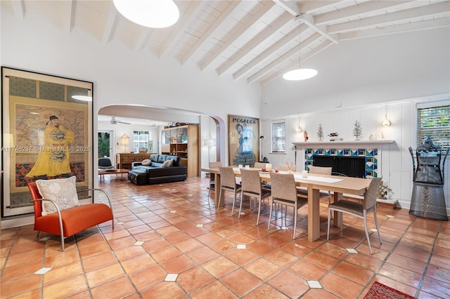 tiled dining room featuring high vaulted ceiling, plenty of natural light, and beam ceiling