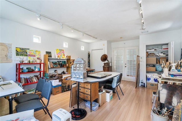 home office featuring rail lighting and light hardwood / wood-style flooring