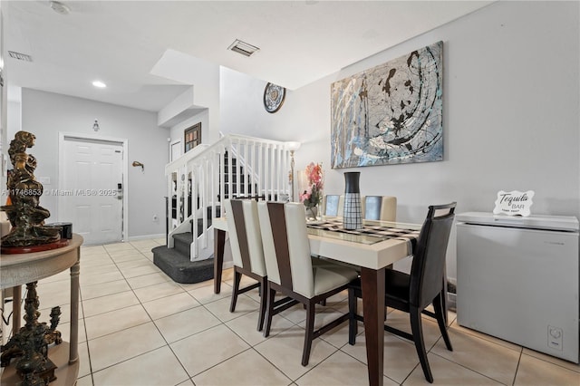 tiled dining space with visible vents, stairway, and baseboards