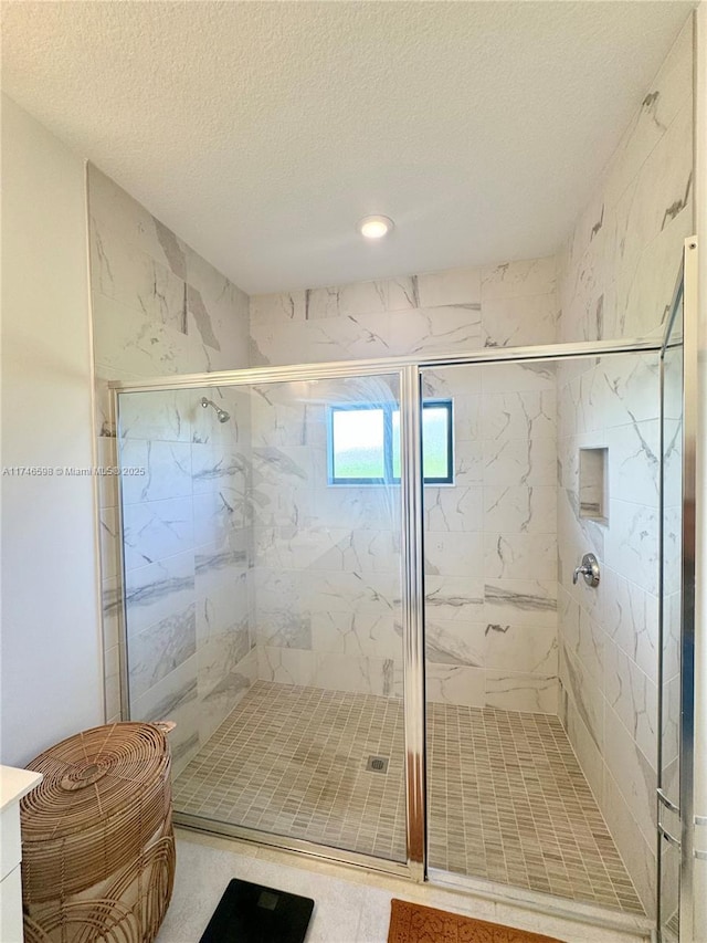 bathroom featuring a textured ceiling and an enclosed shower