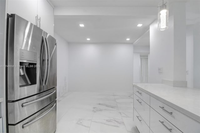 kitchen with white cabinetry, stainless steel refrigerator with ice dispenser, and hanging light fixtures