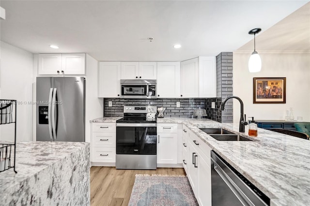 kitchen with pendant lighting, white cabinets, and appliances with stainless steel finishes