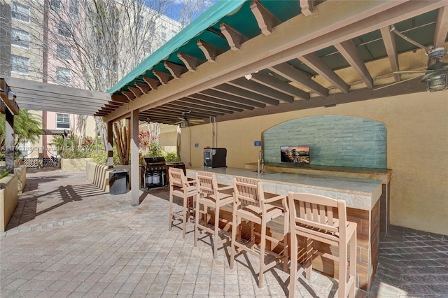 view of patio featuring a bar, ceiling fan, and a pergola