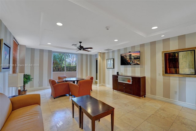 living room with ceiling fan and a tray ceiling