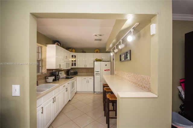 kitchen with light countertops, backsplash, glass insert cabinets, light tile patterned flooring, and white appliances