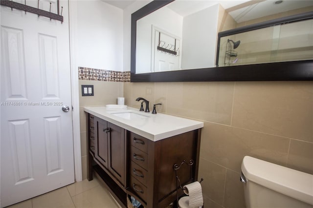bathroom featuring tile walls, toilet, an enclosed shower, vanity, and tile patterned flooring
